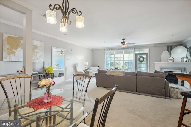 dining space featuring ceiling fan, baseboards, carpet, ornamental molding, and a fireplace