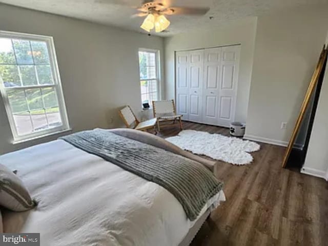 bedroom with a ceiling fan, a closet, baseboards, and wood finished floors