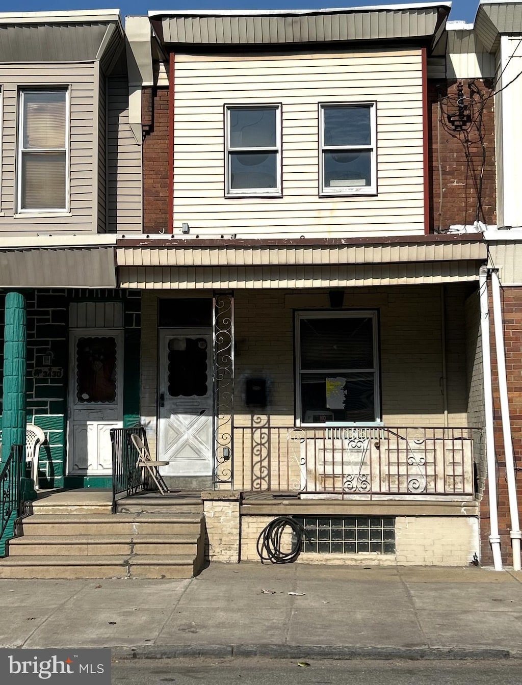 multi unit property featuring a porch and brick siding