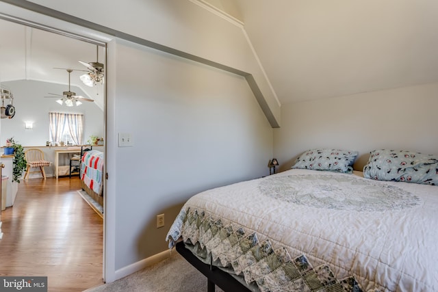 bedroom with wood finished floors, baseboards, and vaulted ceiling