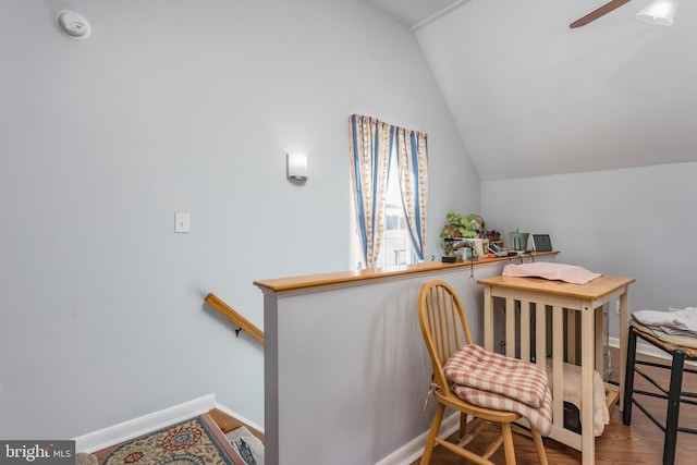 office with a ceiling fan, vaulted ceiling, wood finished floors, and baseboards