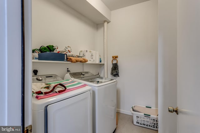 laundry area with baseboards, washing machine and dryer, and laundry area