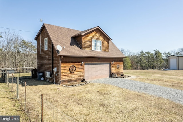 view of property exterior with a lawn, fence, roof with shingles, gravel driveway, and a garage