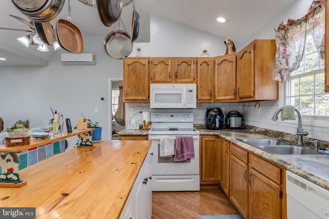 kitchen with a sink, white appliances, backsplash, and vaulted ceiling