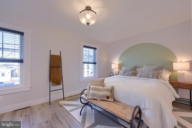 bedroom with light wood-type flooring and baseboards