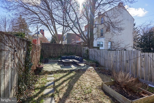 view of yard with a patio area, a fenced backyard, a vegetable garden, and an outdoor living space