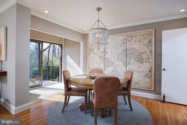 dining space featuring crown molding, wood finished floors, and baseboards