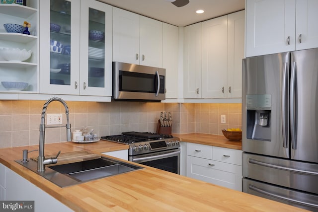 kitchen featuring a sink, stainless steel appliances, and butcher block countertops