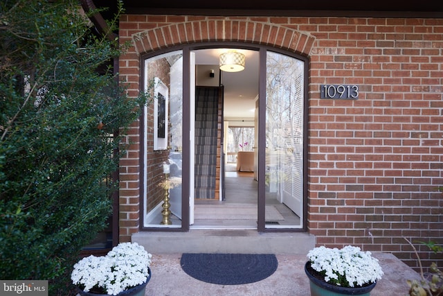 doorway to property with brick siding