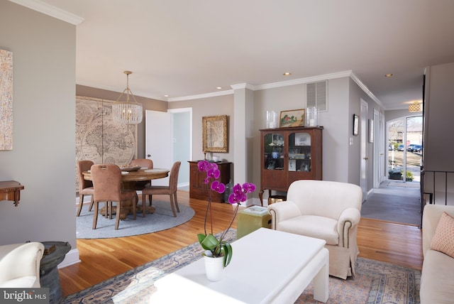 living area featuring crown molding, wood finished floors, and visible vents