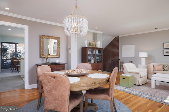 dining space with a chandelier, recessed lighting, light wood-style flooring, and crown molding