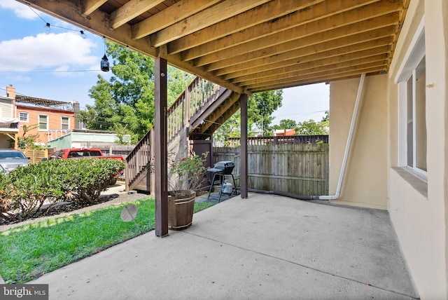 view of patio featuring stairway, area for grilling, and fence