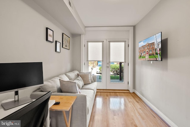 living room featuring light wood-style floors, french doors, and baseboards