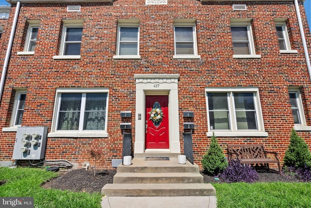 view of exterior entry with brick siding