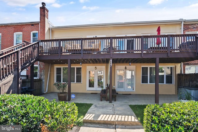 back of property with stucco siding, a patio, and french doors