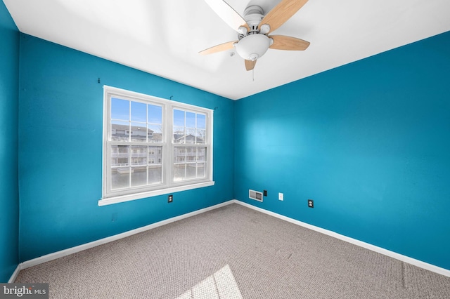 carpeted empty room with ceiling fan, visible vents, and baseboards