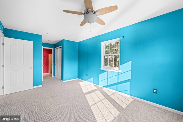 unfurnished bedroom with ceiling fan, baseboards, a closet, and carpet flooring