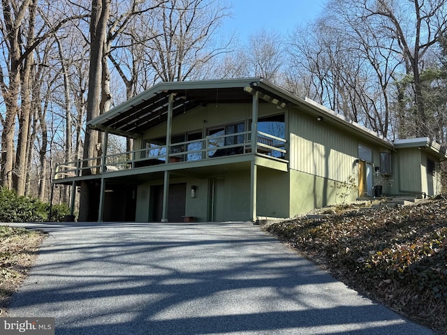 exterior space with aphalt driveway and a balcony