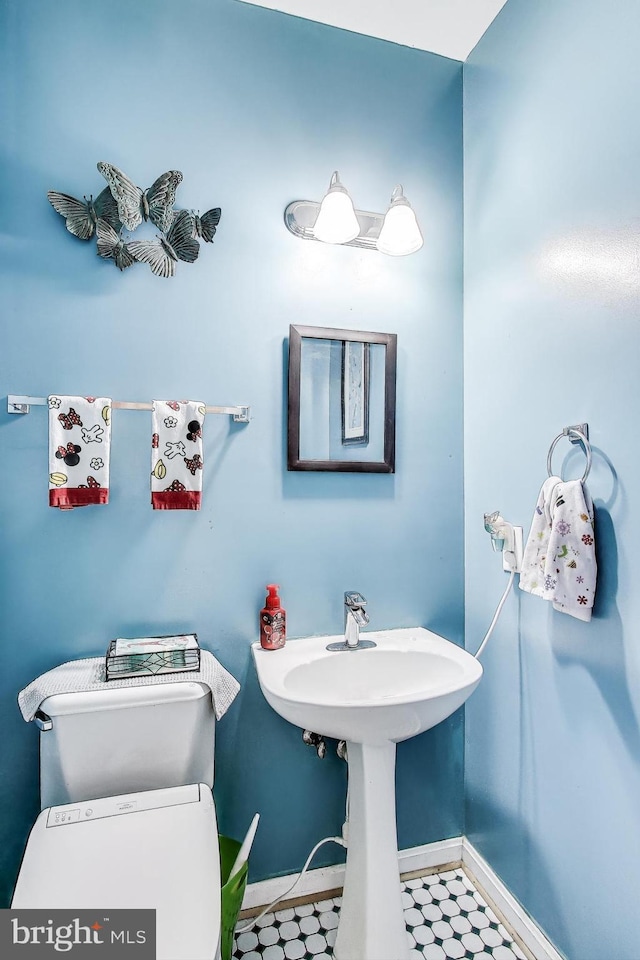 bathroom featuring tile patterned floors, toilet, and baseboards
