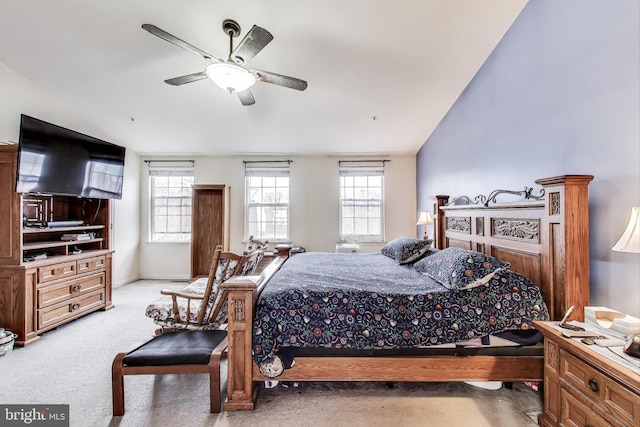 bedroom featuring light colored carpet, a ceiling fan, and multiple windows