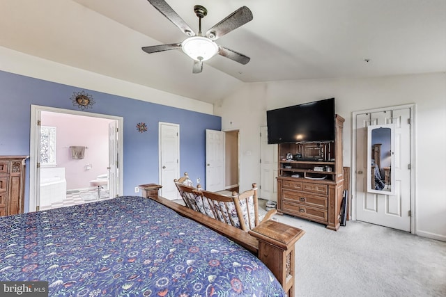 bedroom featuring light colored carpet, ceiling fan, connected bathroom, and vaulted ceiling