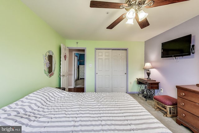 bedroom with a closet, light carpet, baseboards, and ceiling fan