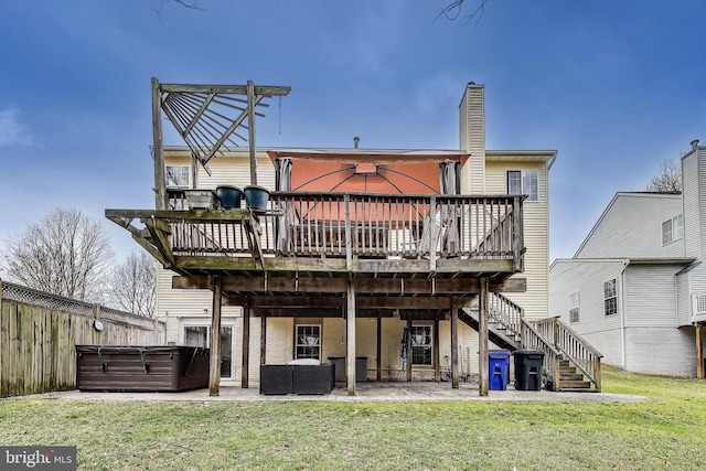 rear view of property with a patio, stairway, a yard, a hot tub, and a deck