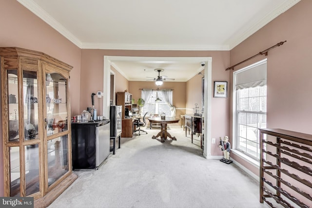 carpeted dining area with ornamental molding, baseboards, and ceiling fan
