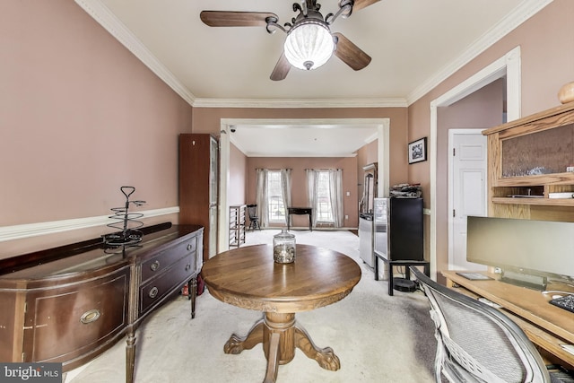 office space with a ceiling fan, crown molding, and carpet