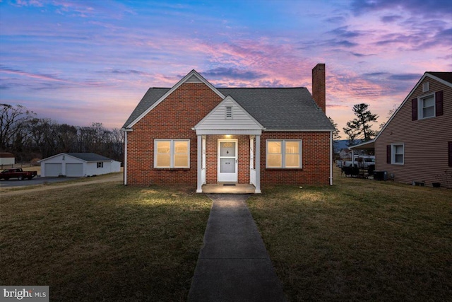 bungalow featuring brick siding, a yard, a chimney, and roof with shingles