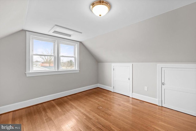 bonus room featuring vaulted ceiling, wood finished floors, and baseboards