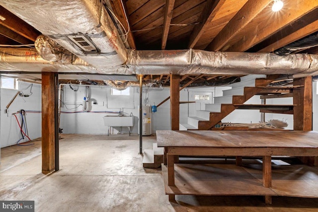 basement featuring water heater, stairway, and a sink