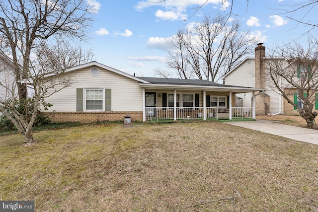 single story home featuring covered porch, driveway, brick siding, and a front lawn