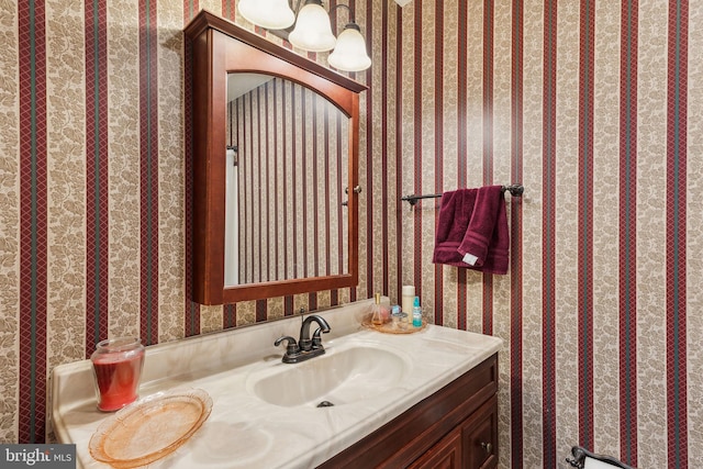 bathroom with wallpapered walls and vanity