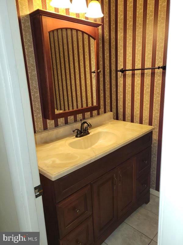 bathroom featuring wallpapered walls, vanity, and tile patterned floors