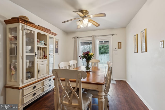 dining area with dark wood-style flooring, ceiling fan, and baseboards