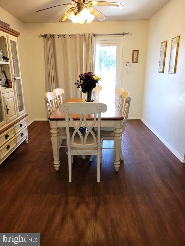 dining area with dark wood-style floors, baseboards, and a ceiling fan