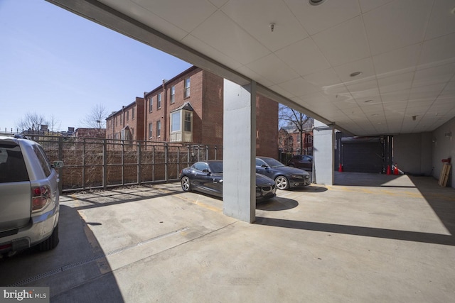 view of vehicle parking with fence