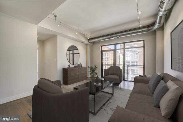 living room with baseboards, track lighting, and wood finished floors