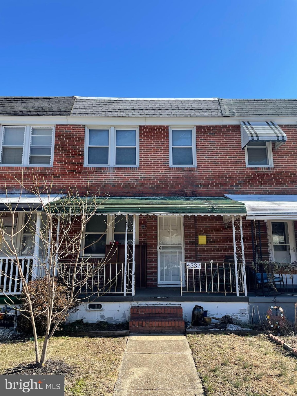 multi unit property featuring covered porch and brick siding