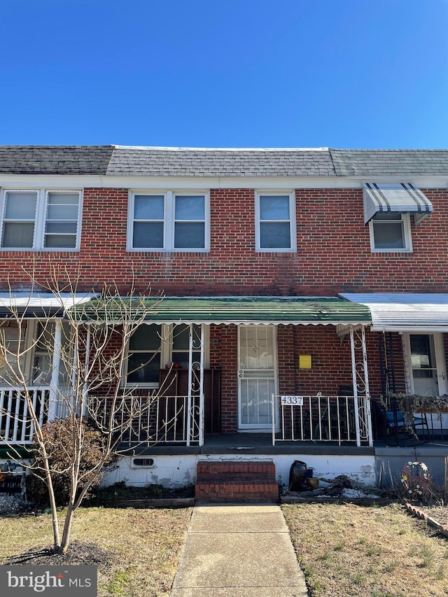 multi unit property featuring covered porch and brick siding