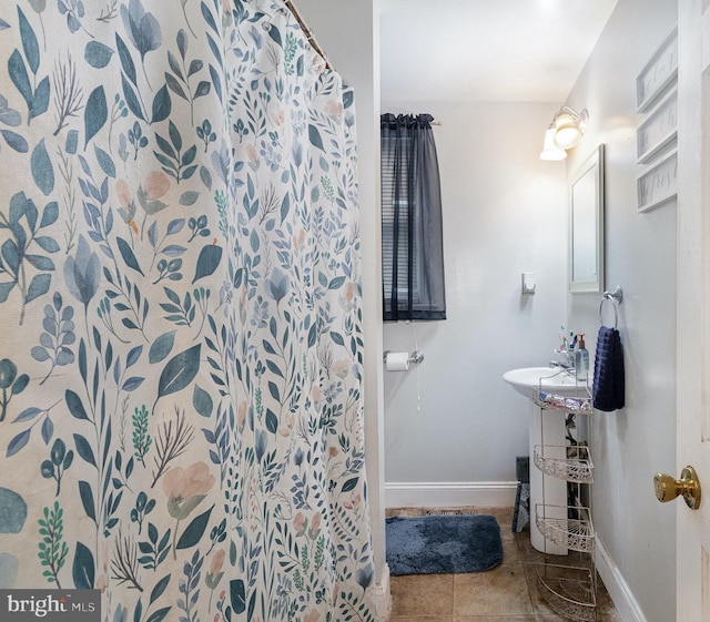 full bath featuring curtained shower, tile patterned flooring, and baseboards