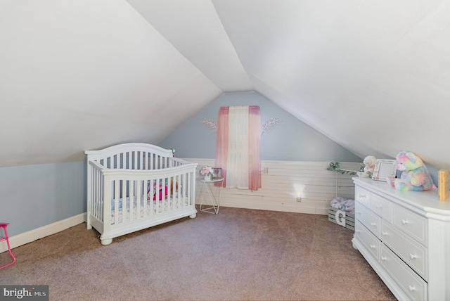 bedroom featuring carpet floors, a nursery area, and lofted ceiling