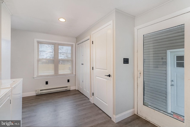 interior space featuring laundry area, baseboards, wood finished floors, washing machine and clothes dryer, and baseboard heating