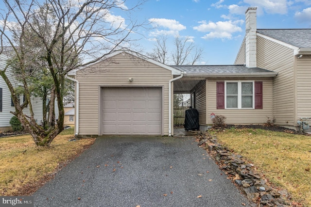 ranch-style house featuring an attached garage, driveway, a shingled roof, and a front yard