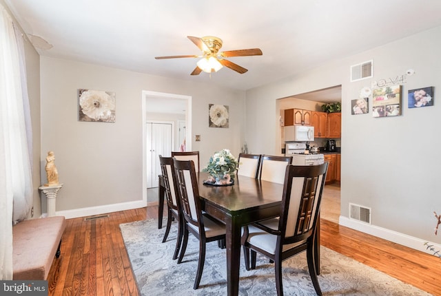 dining space featuring baseboards, visible vents, and wood finished floors