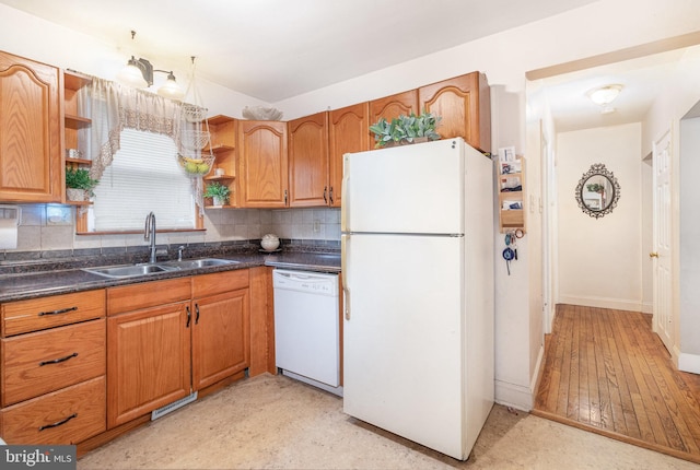 kitchen featuring white appliances, tasteful backsplash, brown cabinets, open shelves, and a sink