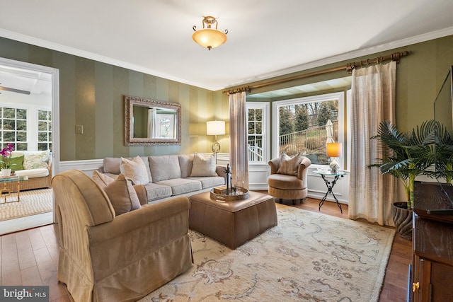 living room with ornamental molding and wood finished floors