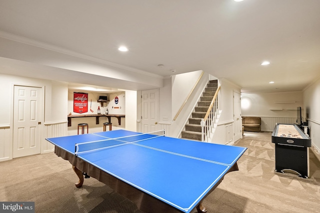 recreation room featuring ornamental molding, recessed lighting, wainscoting, and light colored carpet