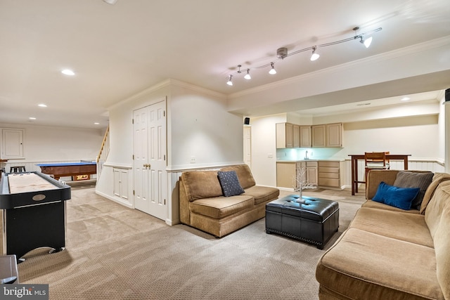 living area with ornamental molding, light colored carpet, and track lighting